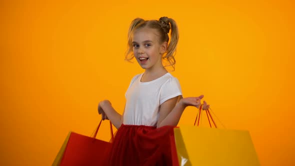Funny Teen Girl Winking and Showing Shopping Bags, Little Shopaholic, Discounts