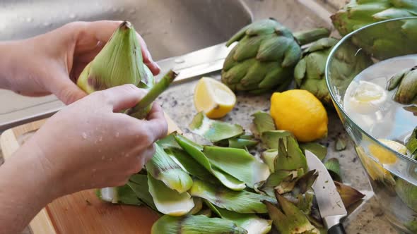 Woman Cleaning Heart of Artichokes with Spoon