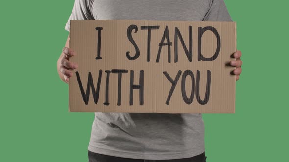 Man Holds in Front of Him a Poster From a Cardboard Box with the Words I STAND WITH YOU. Protest