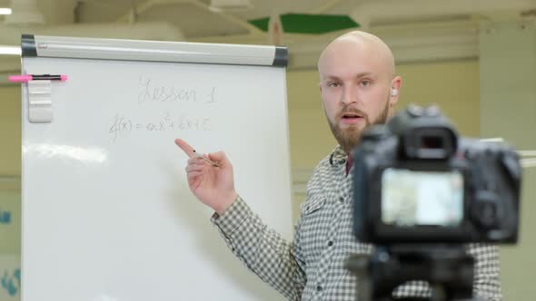 Teacher Records Mathematics Lessons He Stands and Writes with a Pen on a Flip Chart