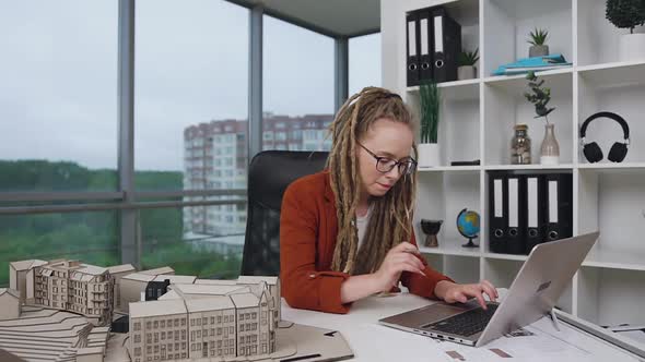 Female Architect with Dreadlocks Working wirh Wooden Construction of Future Buildings 