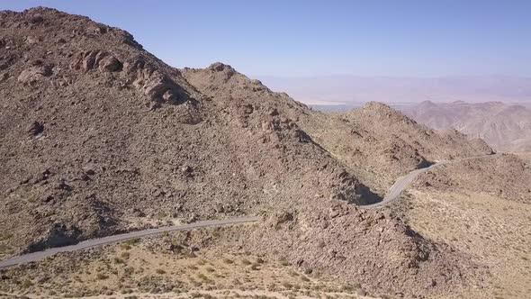 DRONE MOUNTAIN PASS CALIFORNIA DESERT ARID ROAD IN MOUNTAINS