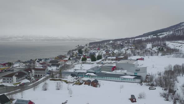 Kåfjord town centre in Olderdalen, Norway. Overcast winter weather.4K aerial drone shot with a side