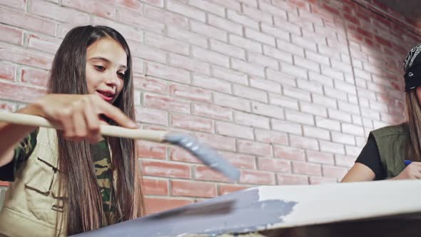 Teenager Using Blue Paint to Decorate White Tile