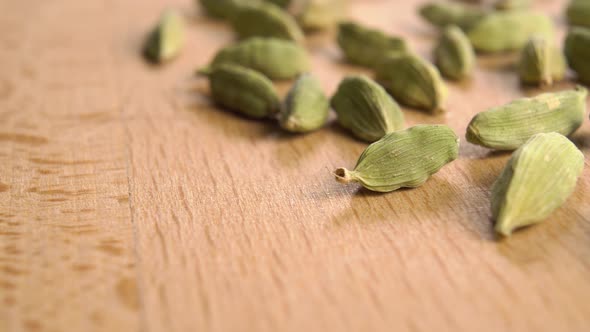 Dried cardamom seeds on a wooden surface