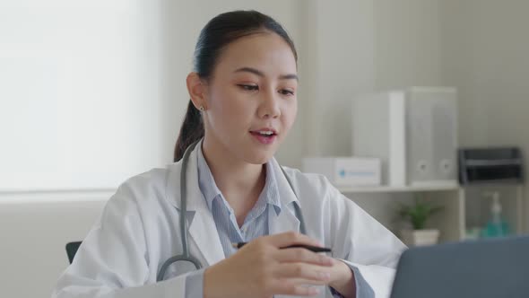 Friendly asian female doctor video call online talk on computer laptop