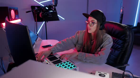 Woman Artist Plays on Synthesizer in Recording Studio