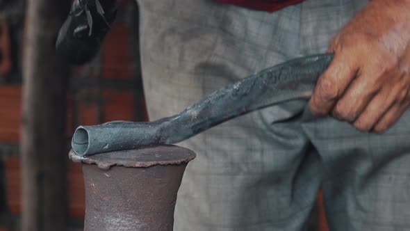 Blacksmith Shaping a Knife with His Hammer