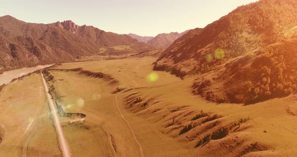 Aerial Rural Mountain Road and Meadow at Sunny Summer Morning. Asphalt Highway and River