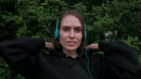 Female Puts on Colored Headphones and Dance