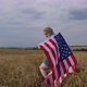 Happy Patriotic Young Woman Holds the US Flag and Walks Across the Field - VideoHive Item for Sale