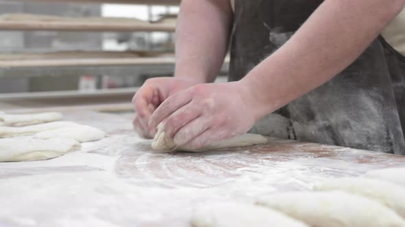 Baker Kneading Dough in a Bakery