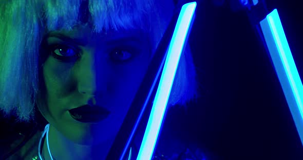 Pretty Woman with White Hair and Makeup Is Posing Next To the Blue Neon Light 