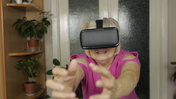 Senior Grandmother Woman in Virtual Headset Glasses Watching 3d Video in 360 Vr Helmet at Home