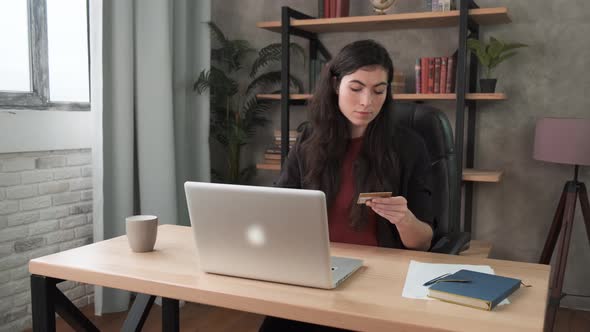 Young Brunette Customer Doing Internet Shopping Holding Credit Card Makes Retail Purchase Secure