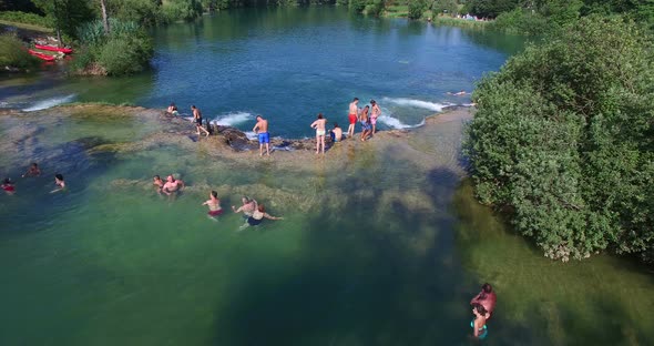 People having a good time and enjoying sunny day at river