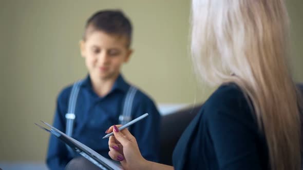 Therapy Session Classroom with Boy Listening the Woman Psychologist Speech