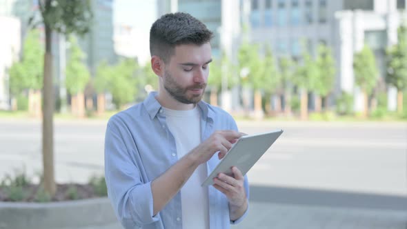 Young Man Using Digital Tablet While Standing Outdoor