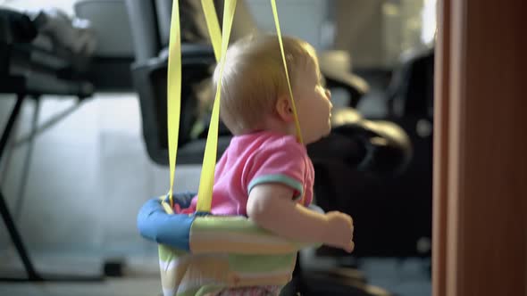 Little Child Jumps with the Help of Special Equipment for Children.