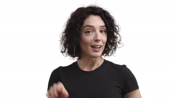 Closeup of Flirty Beautiful Young Woman with Short Curly Hairstyle Wearing Black Tshirt Saying Hello