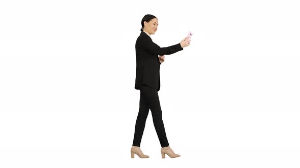 Young Female in a Suit Having Business Video Call on Her Phone on White Background