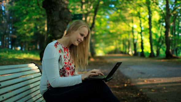 Young Woman Using Her Laptop In the Park