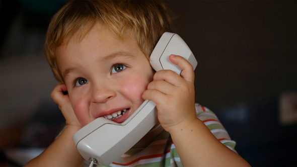 Excited Little Boy Talking Over Telephone Receiver