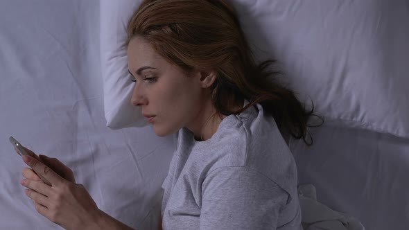 Happy Lady Chatting on Smartphone With Beloved, Lying in Bed, Tender Relations