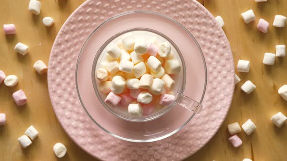 Top View on Cup with Marshmallows on Pink Plate and Wooden Table