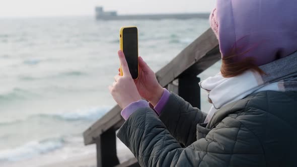 Woman in Warm Clothes Does Photos of the Winter Sea on Her Phone