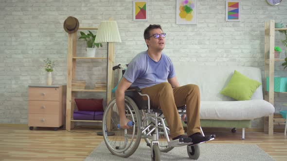 Strong Paralyzed Male Wheelchair Athlete in Sweat Doing Dumbbells