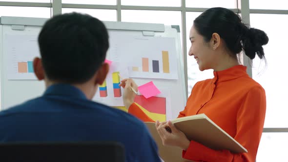 Young Woman Explains Business Data on White Board