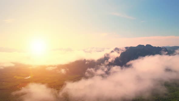 Aerial view from a drone over mountain fog during sunrise