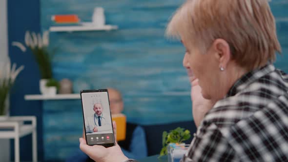 Middle Aged Woman Talking at Video Conference Calling with Remote Doctor