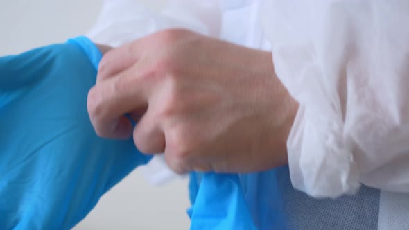 Closeup of the Hands of a Doctor Who Puts on Disposable Surgical Gloves Made of Blue Latex