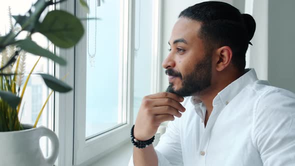 Good-looking African American Man Looking at Window Then Drinking Coffee at Home Alone