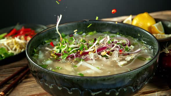 Super Slow Motion Shot of Ingredients Falling Into Chicken Pho Soup at 1000 Fps