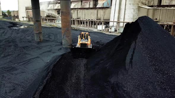 Crawler bulldozer sorts coal. Industry. Aerial view.