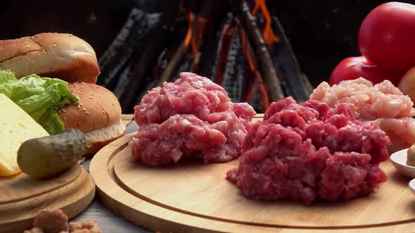 Chicken Beef and Pork Raw Minced Meat on the Background of an Open Fire