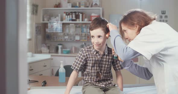 Female doctor examining a young boy in the clinic