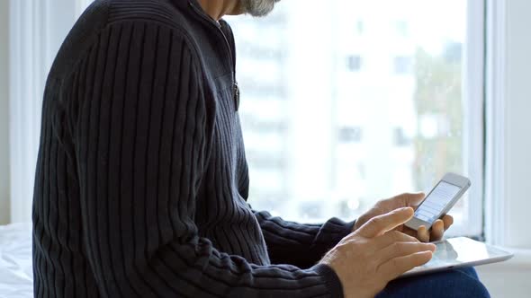 Man using digital tablet and mobile phone in bedroom 4k