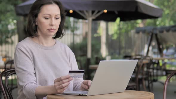 Online Shopping Failure for Old Woman Sitting Outdoor