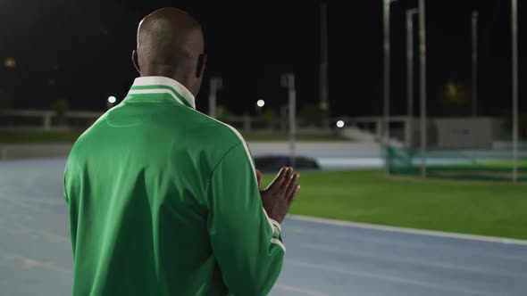 African american male coach clapping watching disabled male athlete with running blade training