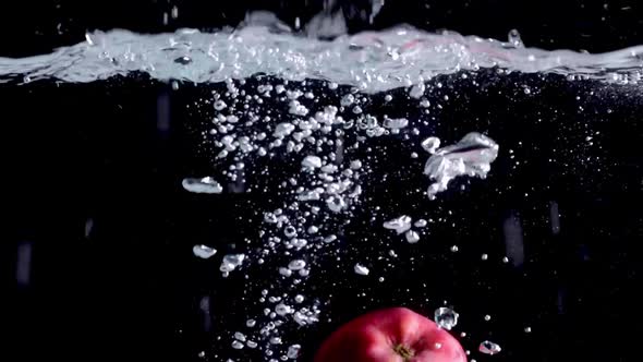 Fruits Fall Into the Water on a Black Background