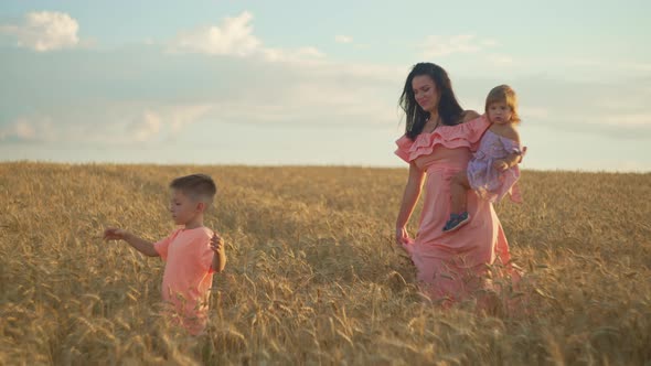 A Family Walks Together Through a Wheat Field