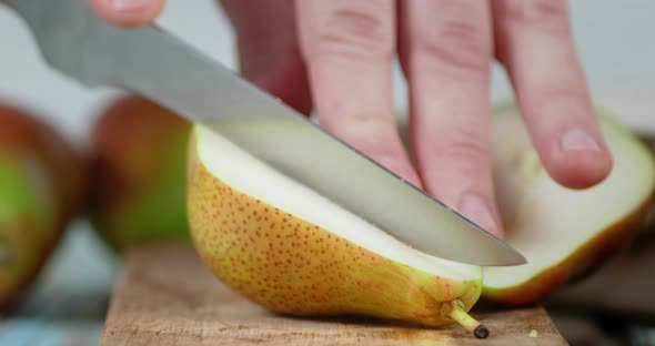 Hands Men Cut the Pear Into Two Pieces. 