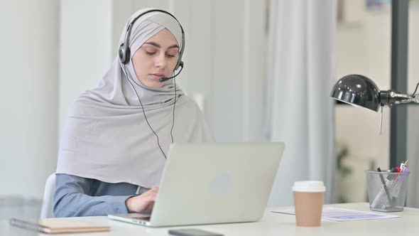 Young Arab Woman with Headset Working on Laptop