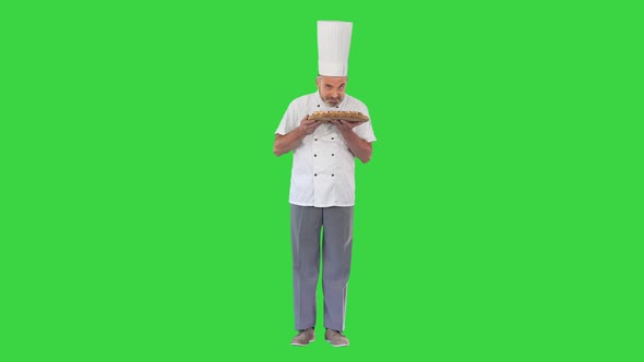 Happy Chef Smelling a Pizza and Offering It To You on a Green Screen Chroma Key