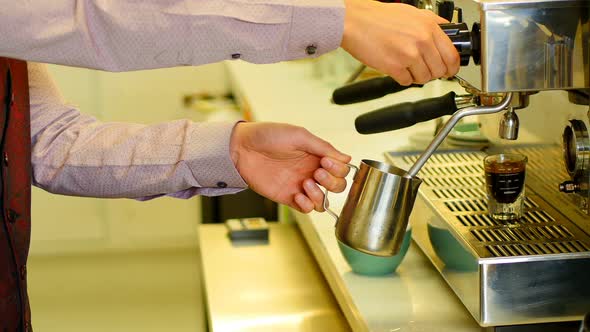 Mid section of waiter making espresso