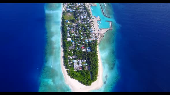 Aerial drone shot panorama of idyllic resort beach break by transparent water with white sand backgr